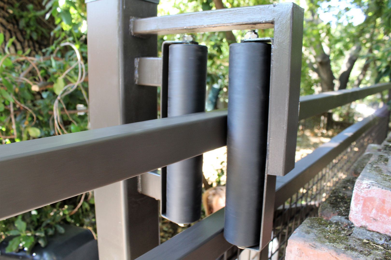 A close up of a metal fence with rollers attached to it.