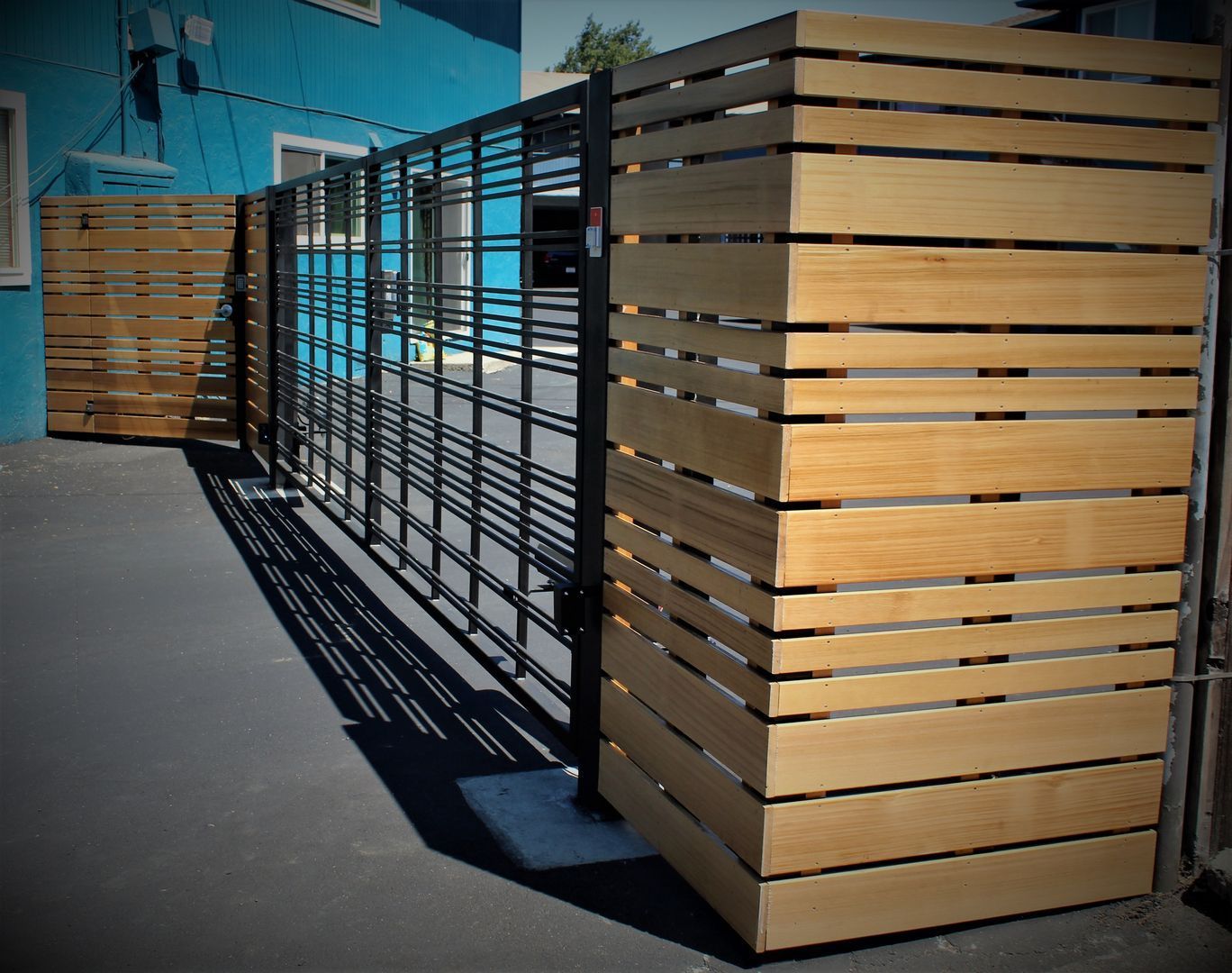 A wooden fence with a blue building in the background