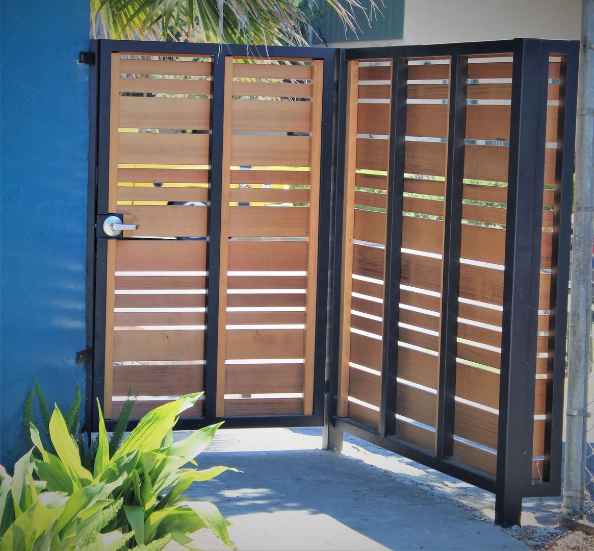 A wooden gate with a black frame is open