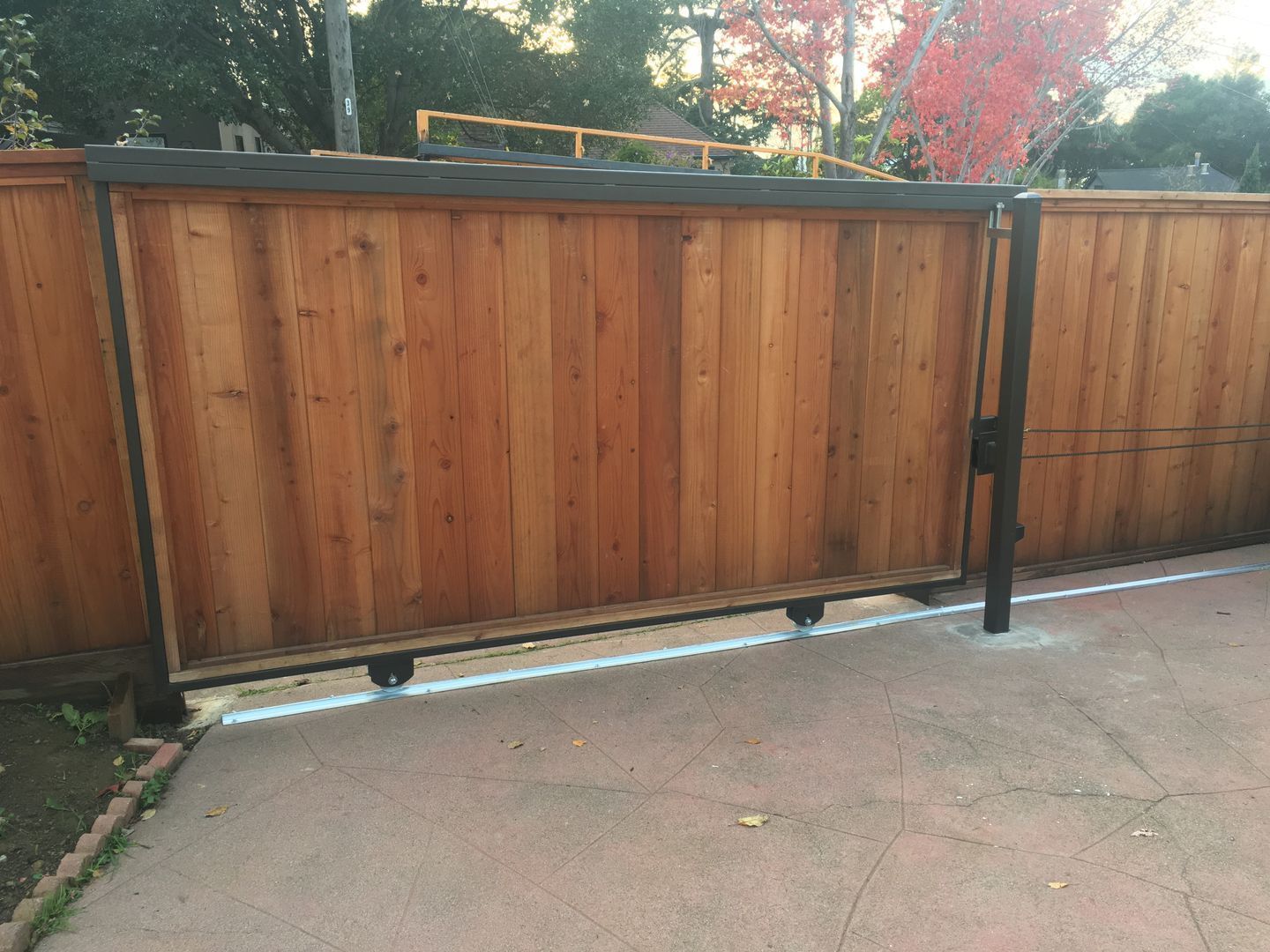 A wooden fence is sitting on top of a concrete driveway.