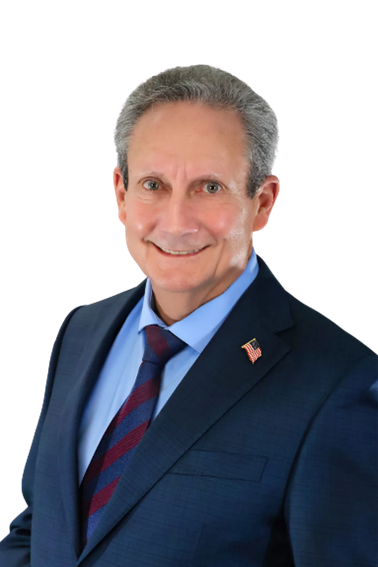 Man in a blue suit, smiling. Red and blue striped tie. American flag pin.