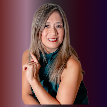 Woman pointing upward, smiling; teal top, shoulder-length light brown hair; reddish-purple gradient background.