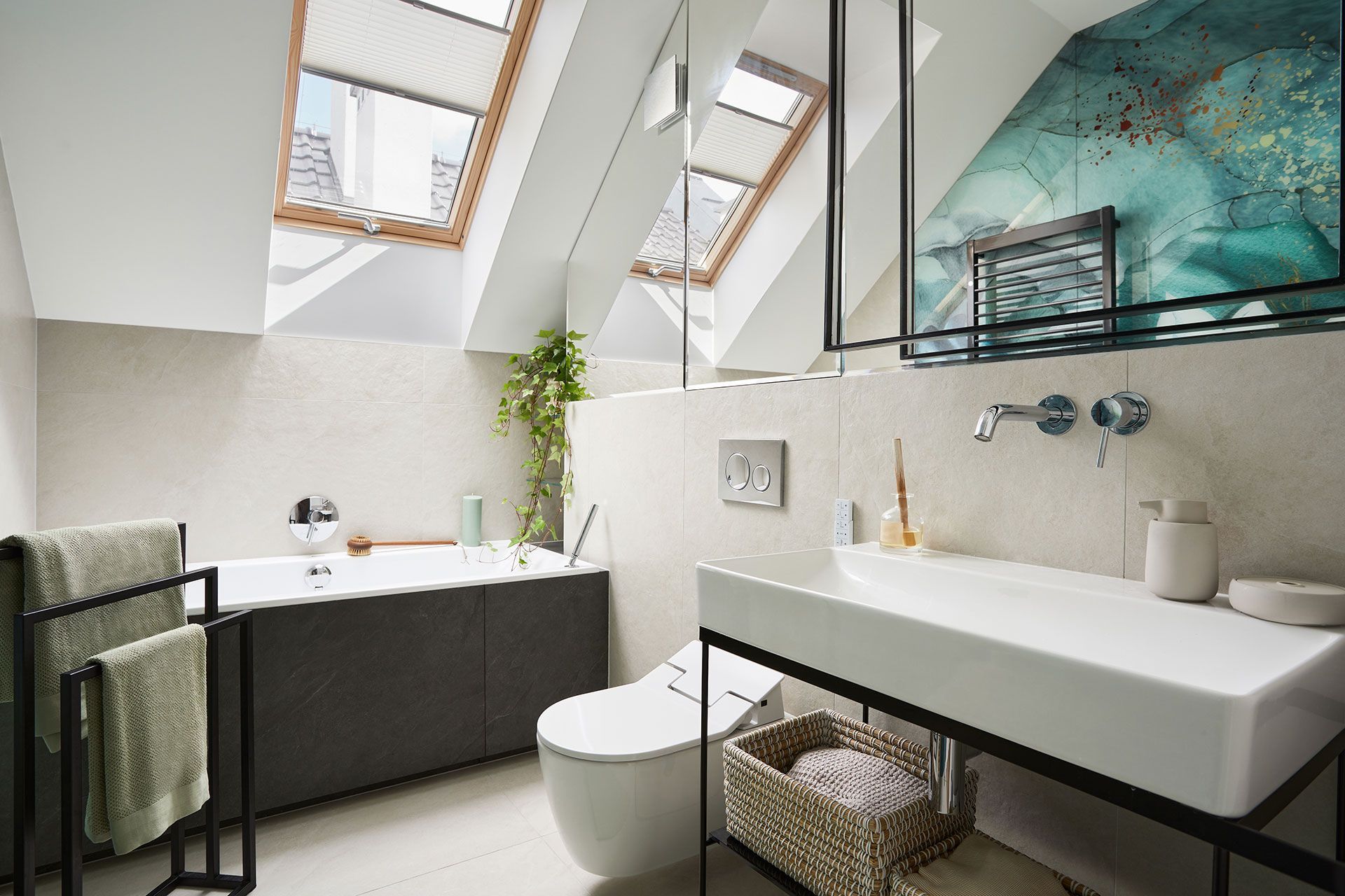 A bathroom with a sink , toilet , tub and skylight.