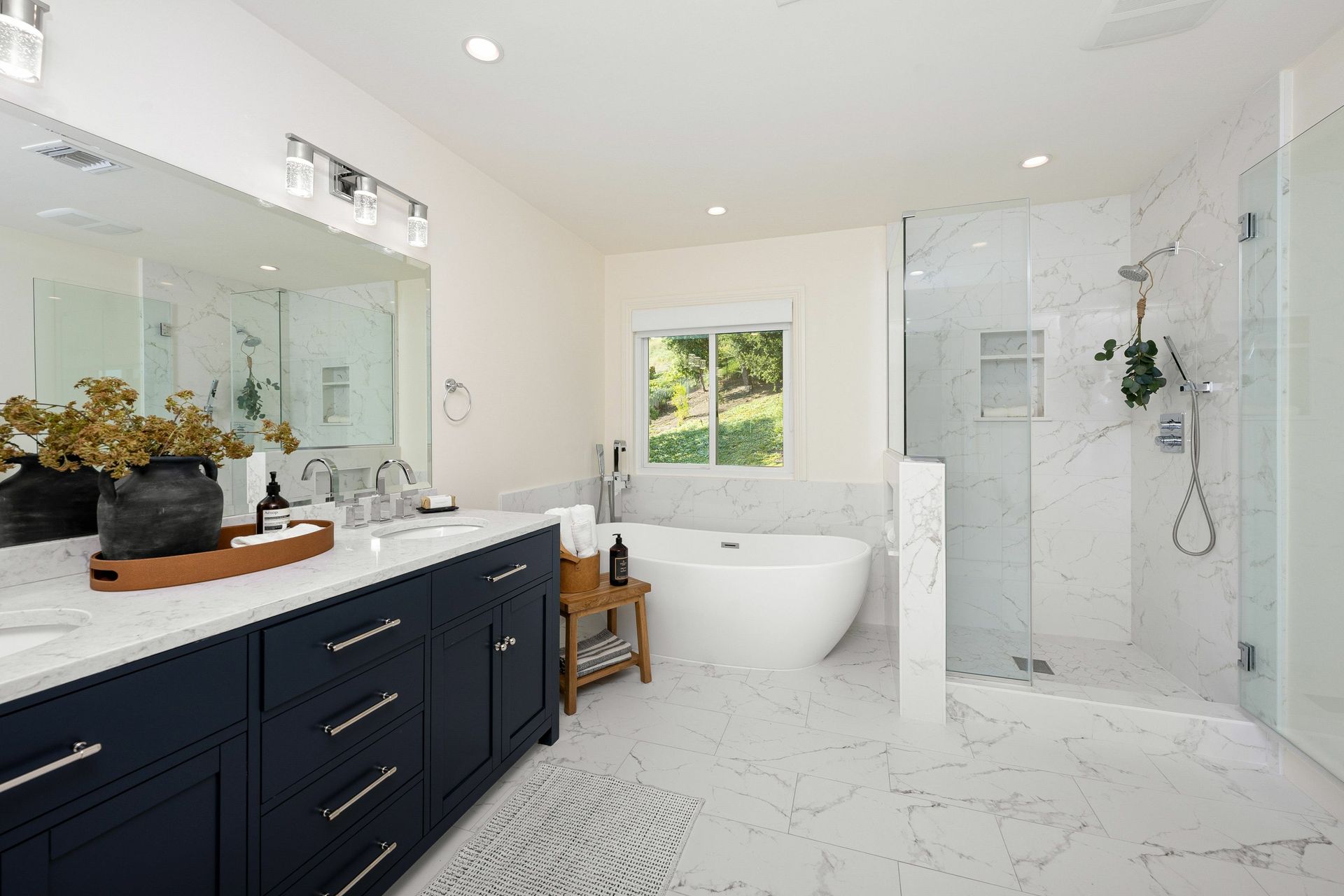 A bathroom with two sinks , a tub , and a walk in shower.