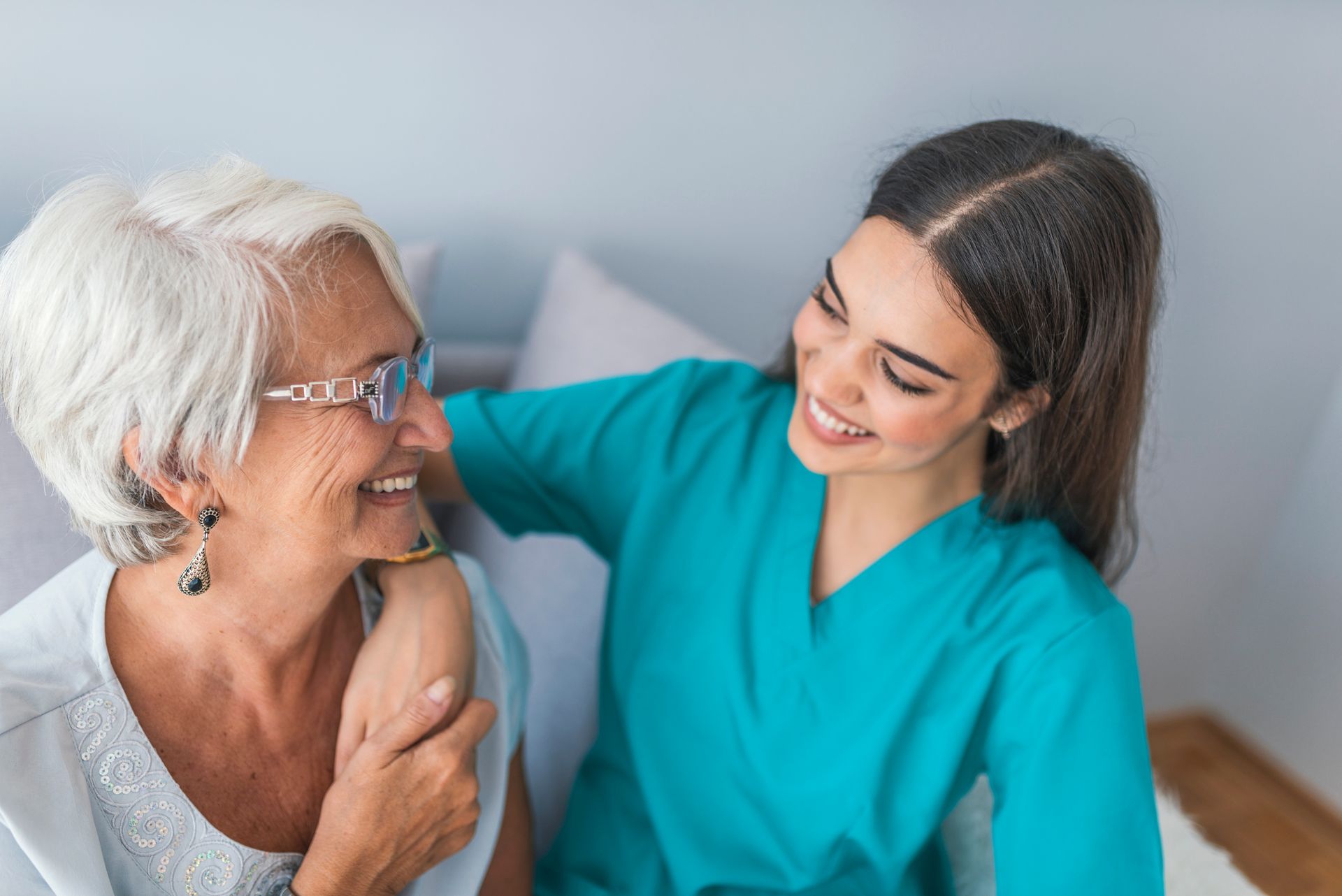 A care nurse practitioner is providing compassionate in-home medical care to an elderly woman.