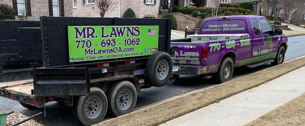 Purple truck with trailer, Mr. Lawns landscaping business. On a residential street.