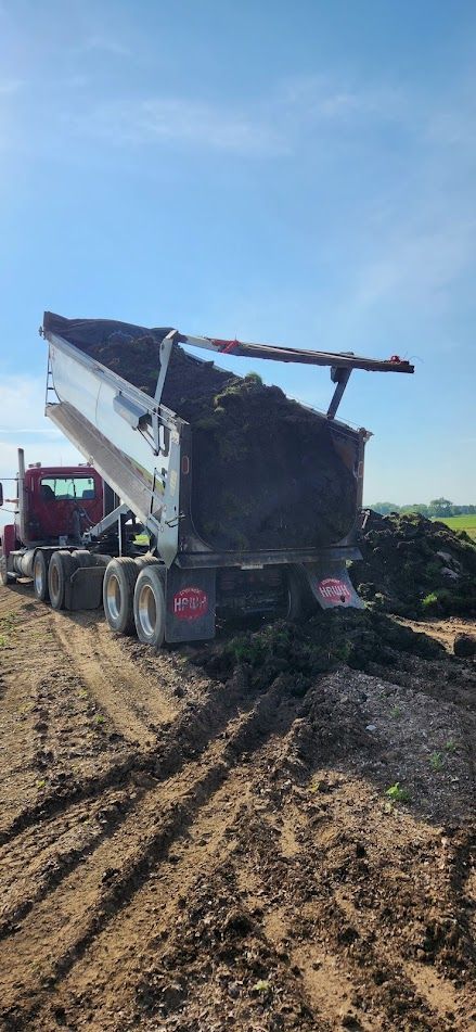 Flatbed truck hauling a heavy machine for construction Flatbed truck hauling a heavy machine for construction