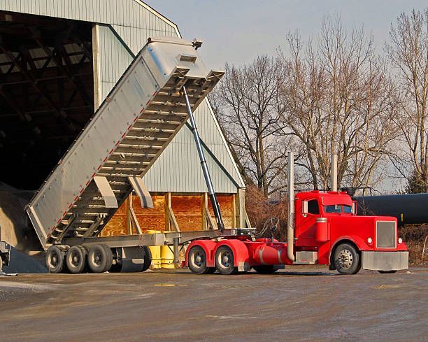 Truck hauling a large black pipes on highway Truck hauling a large black pipes on highway