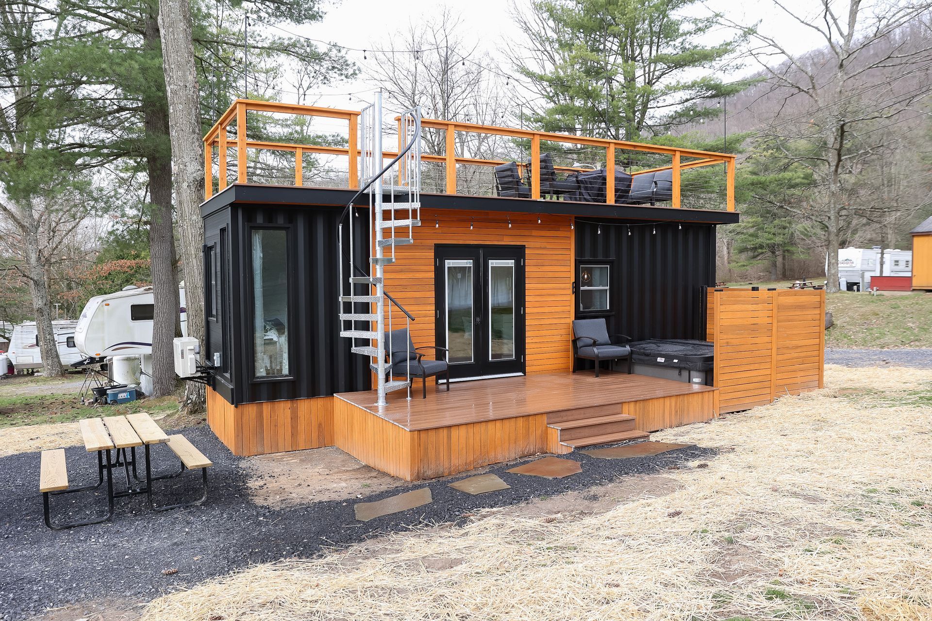 A small wooden house with a balcony on top of it.