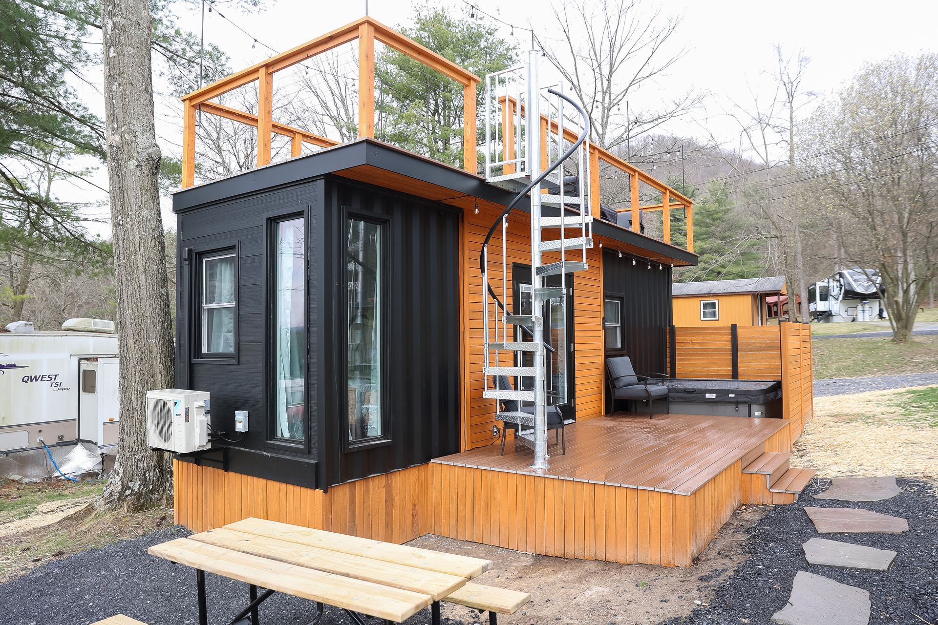 A small house with a wooden deck and stairs.