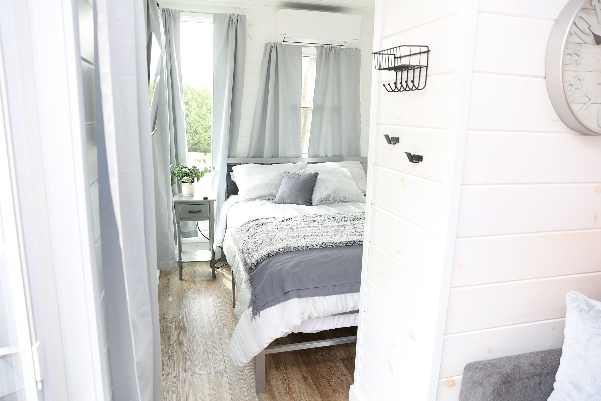 A bedroom with a bed and a clock on the wall.