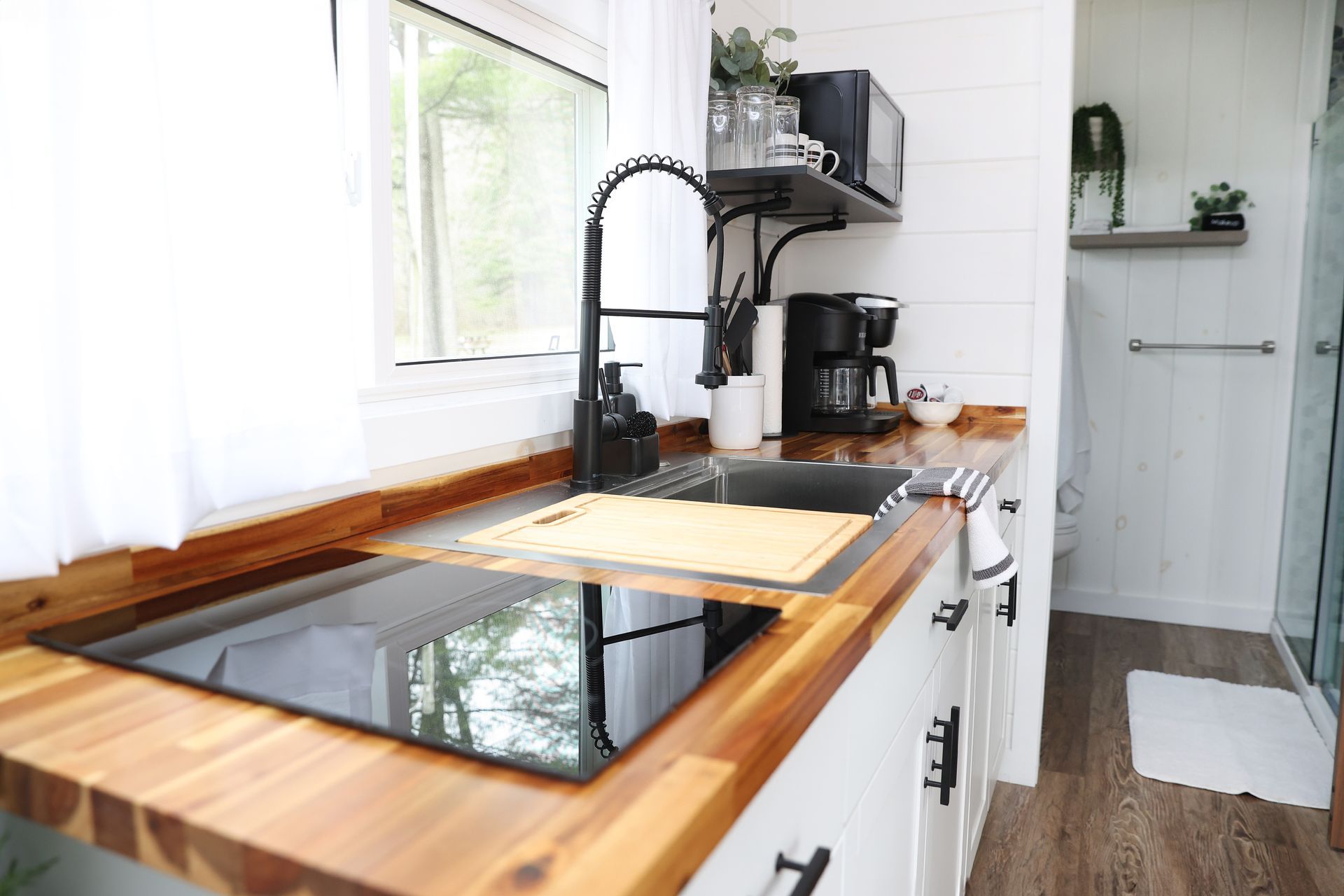A kitchen with a sink , stove top oven , and microwave.