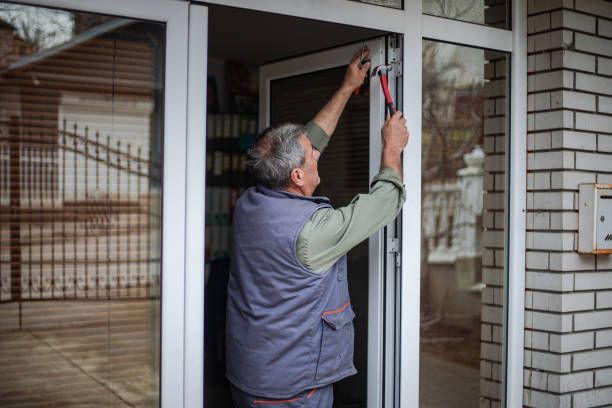 A professional worker is installing a door on the house.