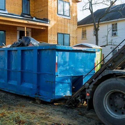 A dump truck with a large pile of wood on top of it