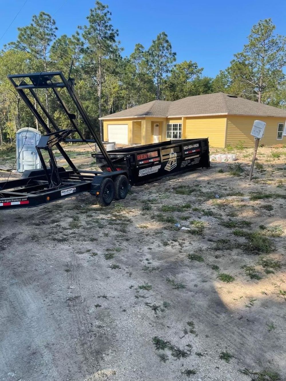 A dumpster trailer is parked in front of a house.