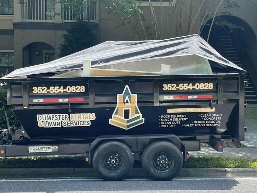 A dumpster rental trailer is parked on the side of the road