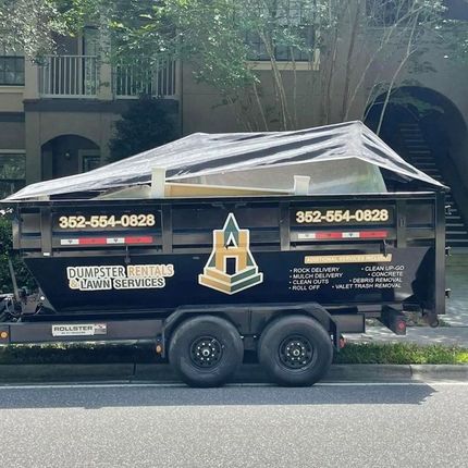 A dumpster rental trailer is parked on the side of the road