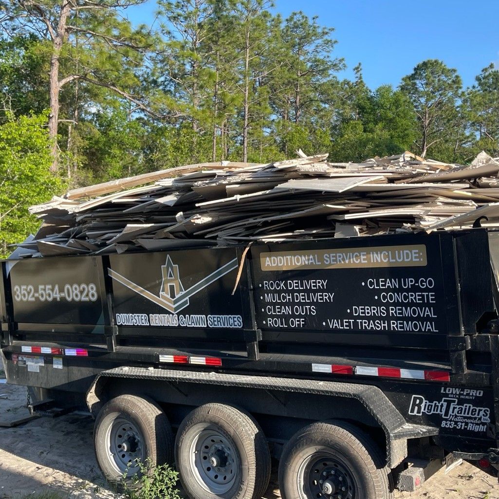 A dump truck with a large pile of wood on top of it