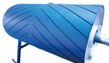 Tambor de cinta transportadora de color azul con ranuras diagonales, apoyado sobre un soporte.