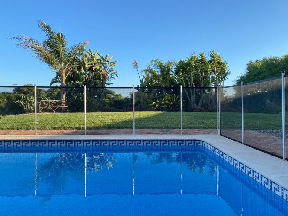 A Large Swimming Pool With A Fence Around It — CQ Fencing & Retaining Walls In Clinton, QLD
