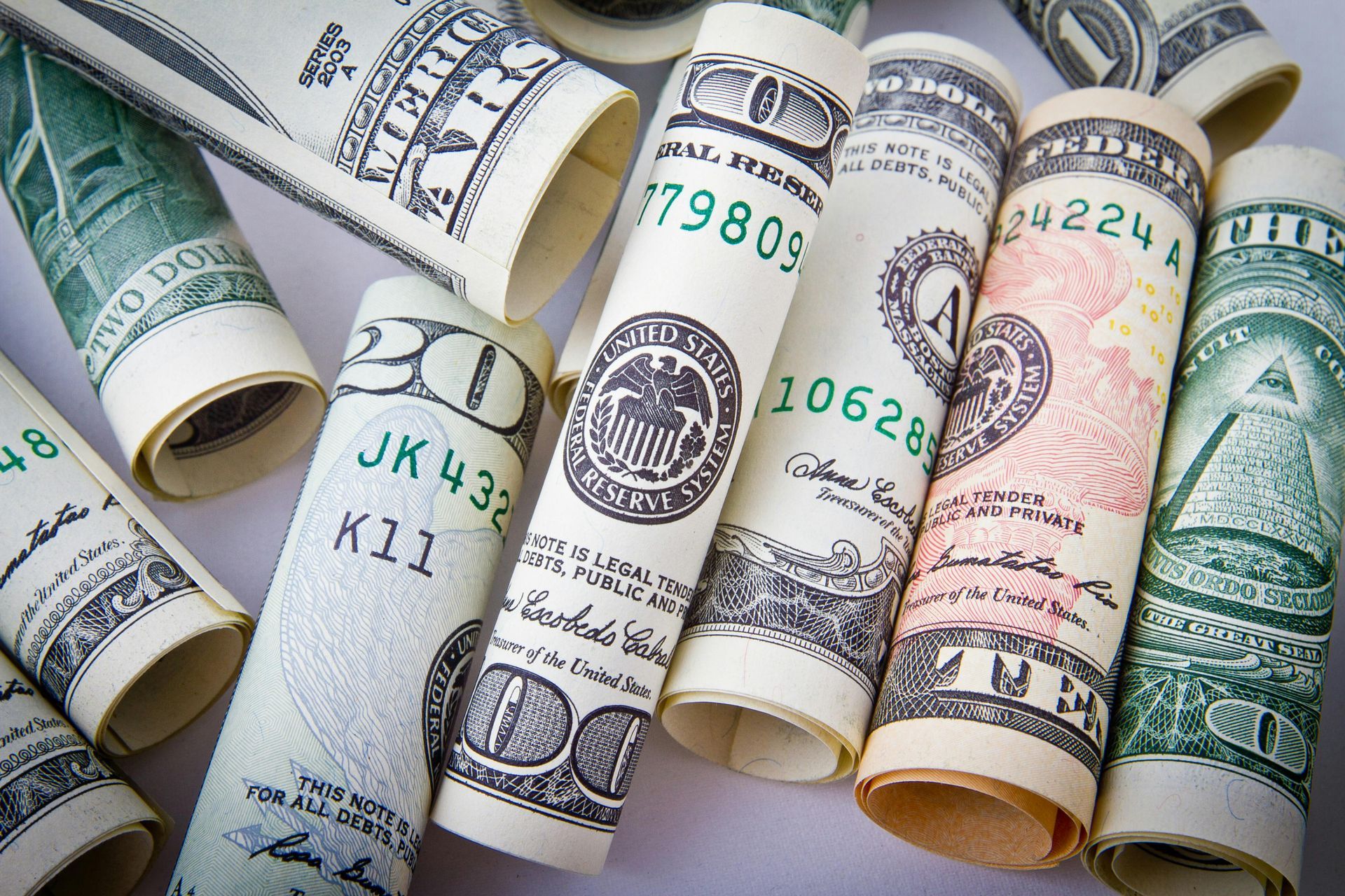 A bunch of rolled up dollar bills on a table