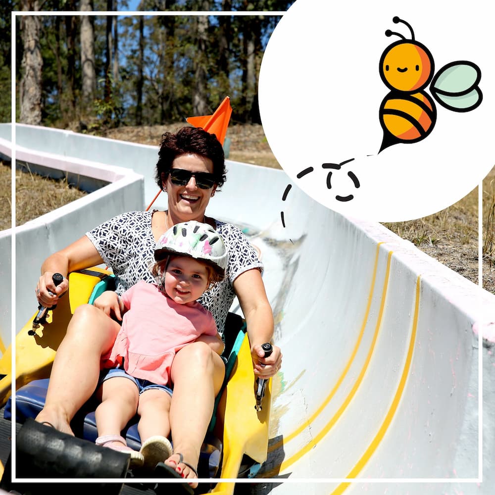 Mother and Daughter Riding Toboggan In The Big Buzz Fun Park in Rainbow Flat, NSW