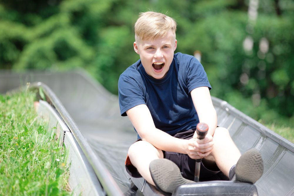 Teenage Boy Enjoying A Toboggan Ride