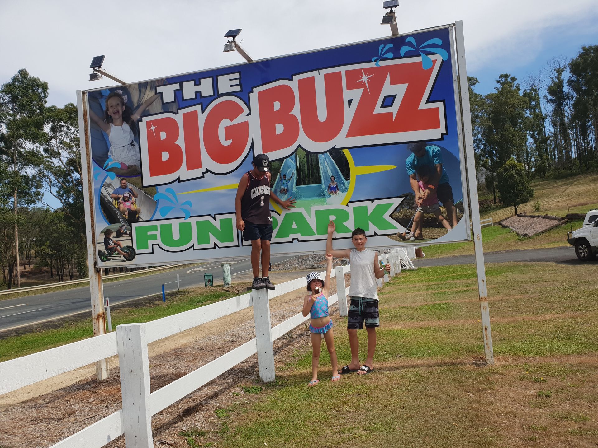 Three Kids in Front of Big Signage