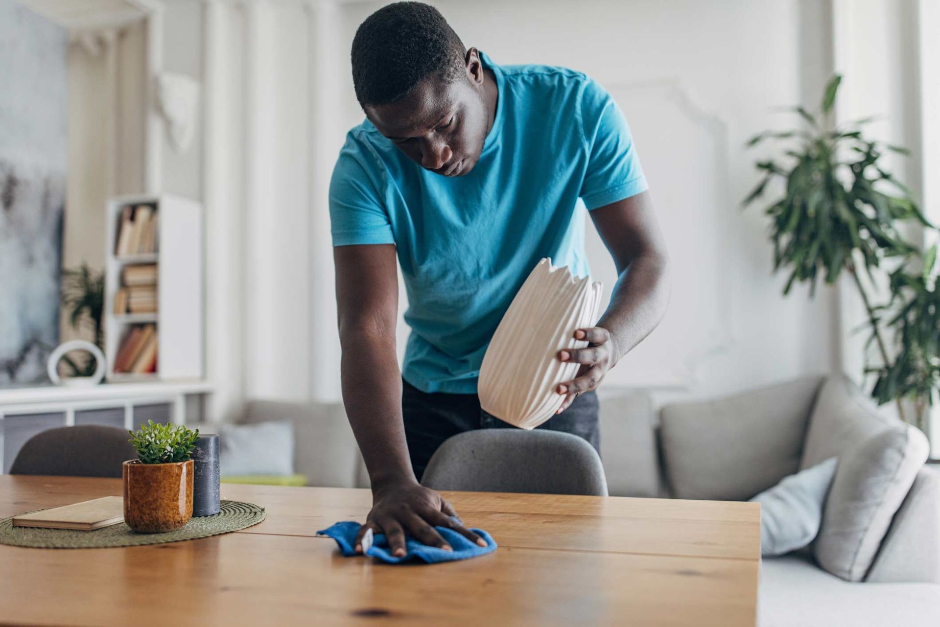 A person is cleaning a couch with a steam cleaner.