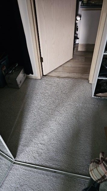 A person is standing in front of a mirror in a hallway.