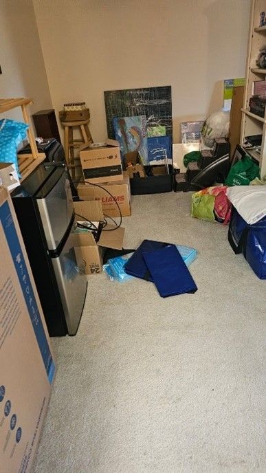 A room filled with lots of boxes and a refrigerator.