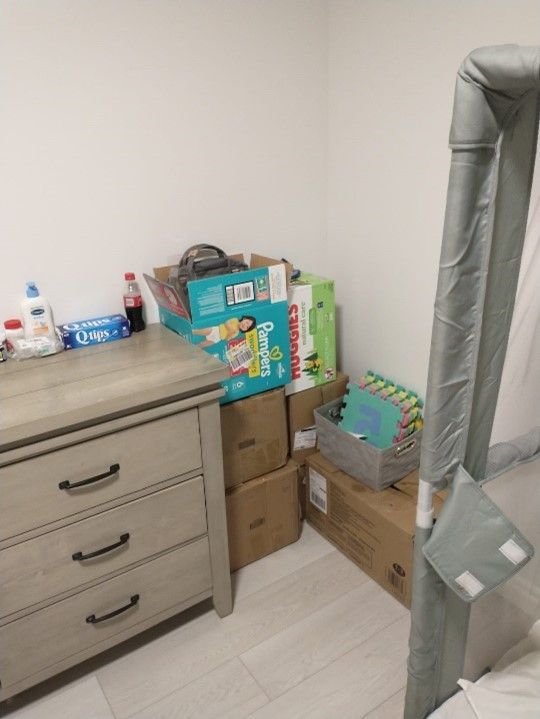 A room filled with lots of boxes and a dresser.