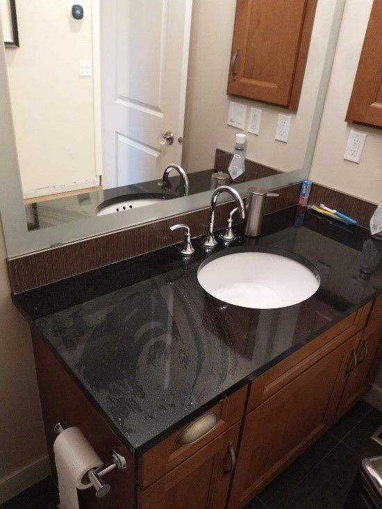 A bathroom counter with a sink and a mirror