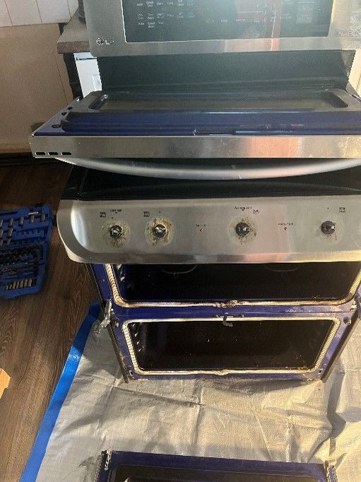 A stove and microwave are sitting on top of each other on a table.