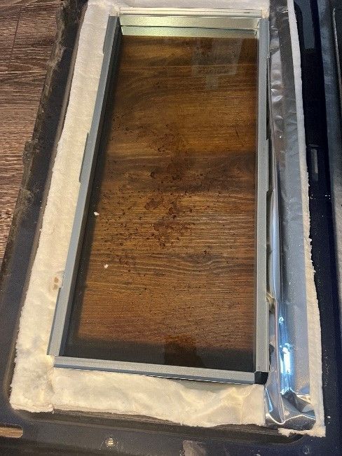 A piece of glass is sitting on top of a wooden table.