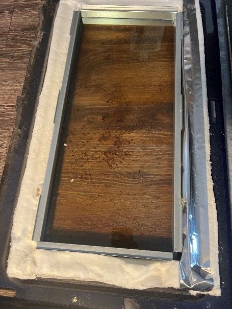 A piece of glass is sitting on top of a wooden table.