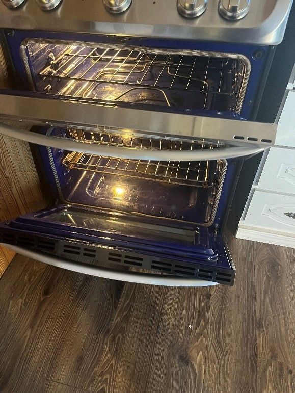 A stove with the door open and a light inside of it.