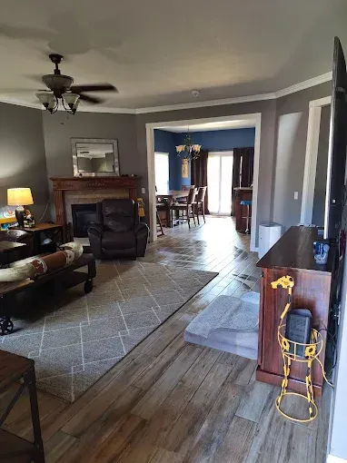 Living room with fireplace, recliner, and dining area visible in the distance.