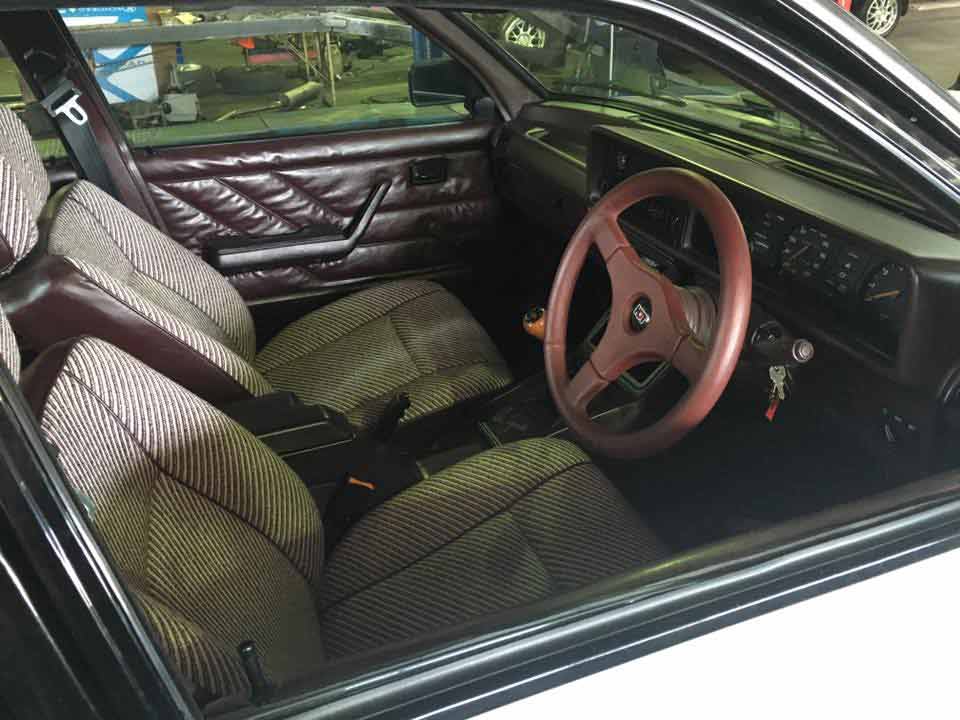 the inside of a car with a red steering wheel