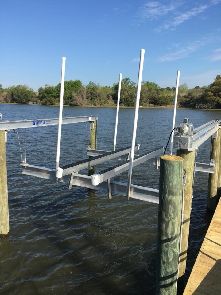 A boat lift is attached to a wooden dock in the water