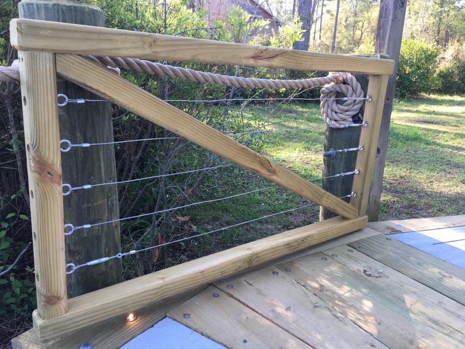 A wooden gate with ropes attached to it is sitting on a wooden deck