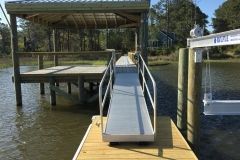 A dock with a ramp leading to a house on the water