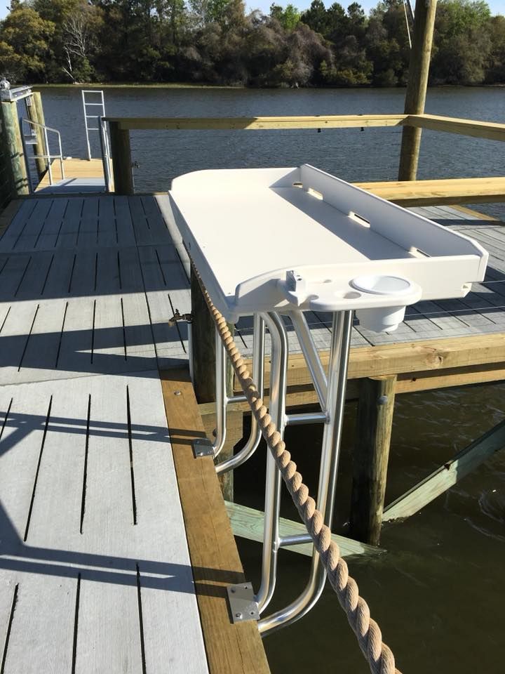 A white table is attached to a dock by a rope