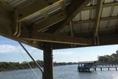 A wooden structure overlooking a body of water with a dock in the background