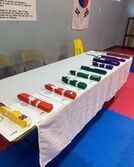 There are many different colored belts on the table.