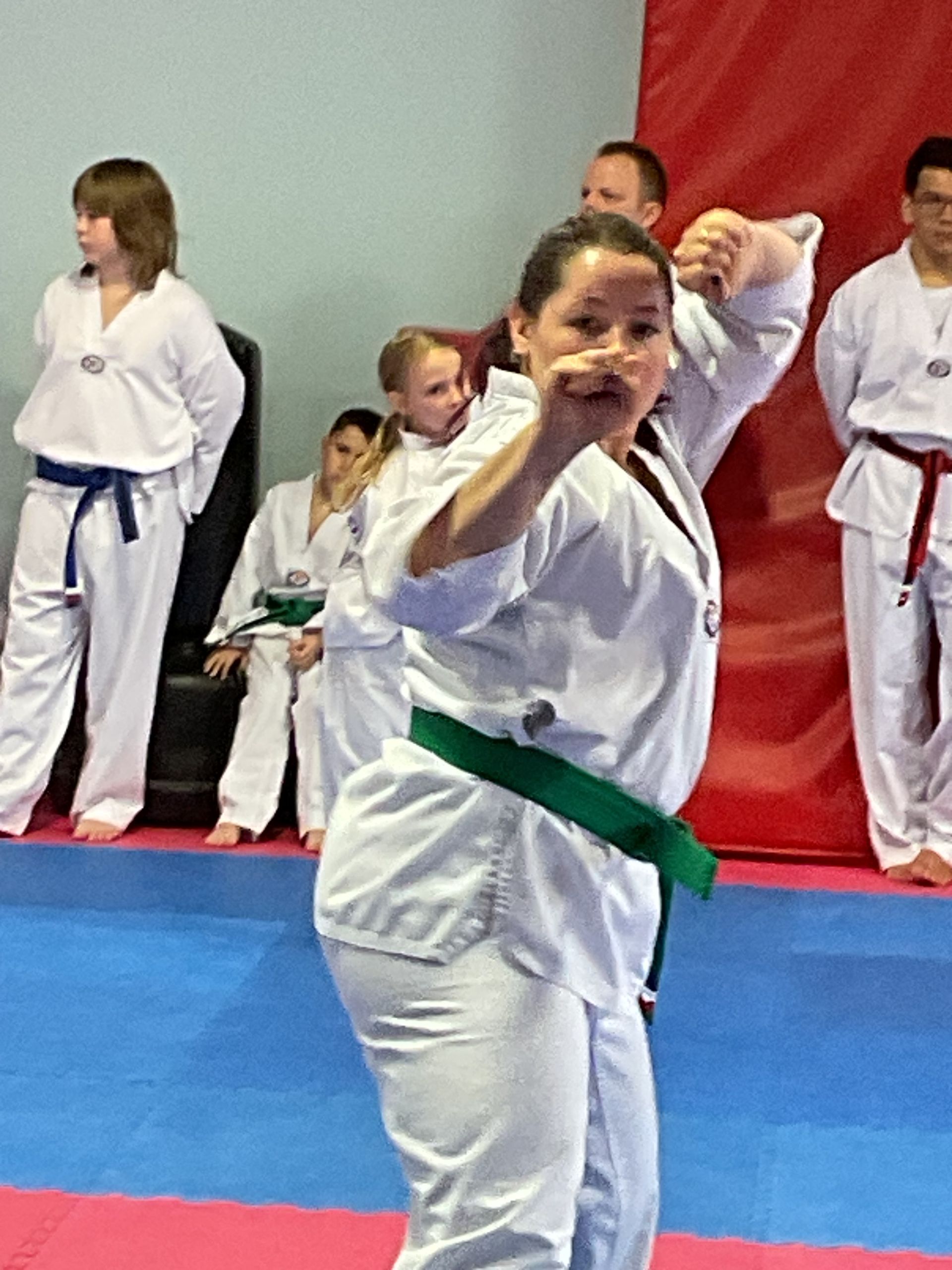 A woman with a green belt is practicing martial arts