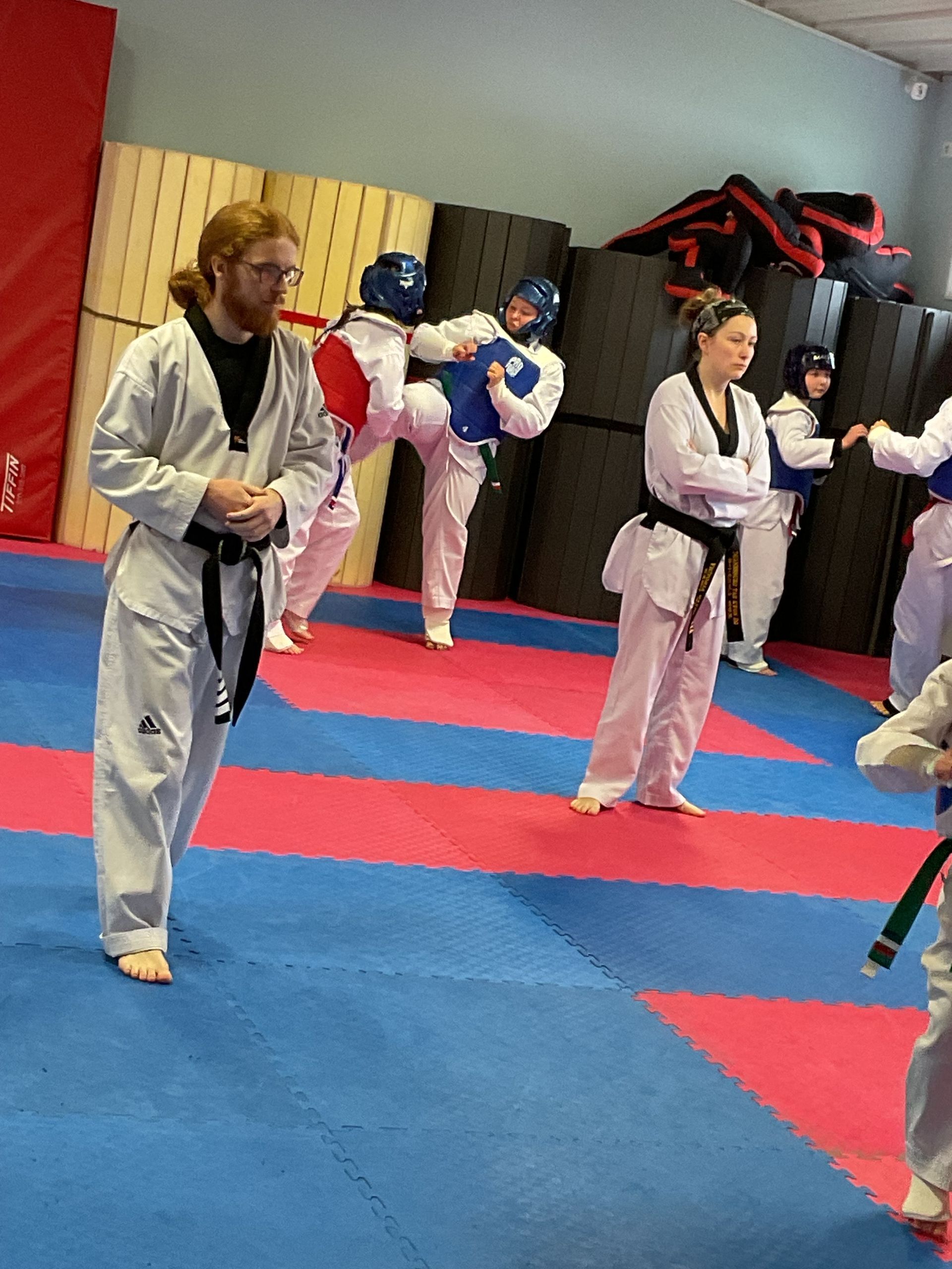 A group of people are practicing martial arts in a gym.