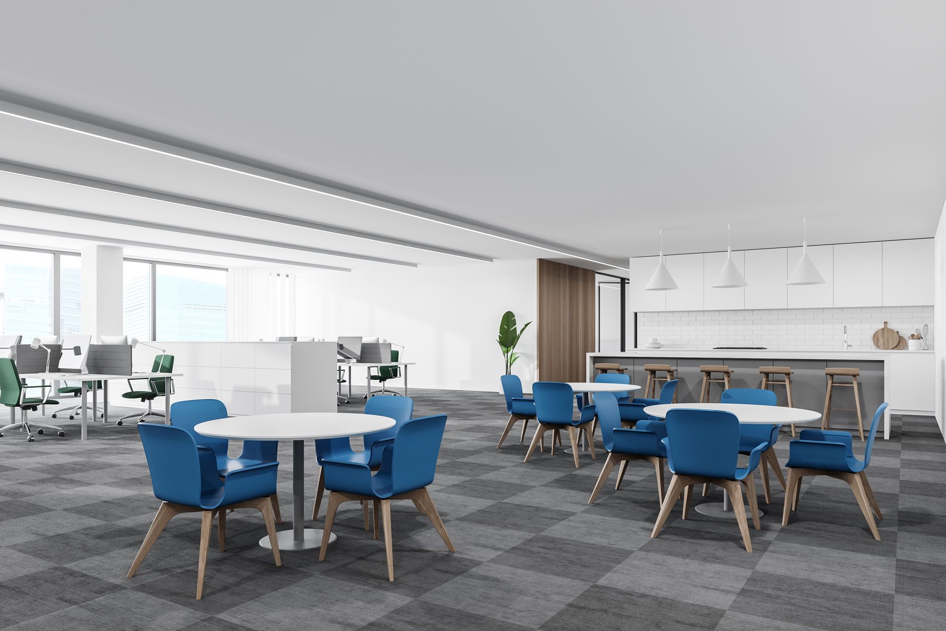 Office breakroom with blue chairs, round tables, and a kitchen area. White walls and gray checkered carpet.