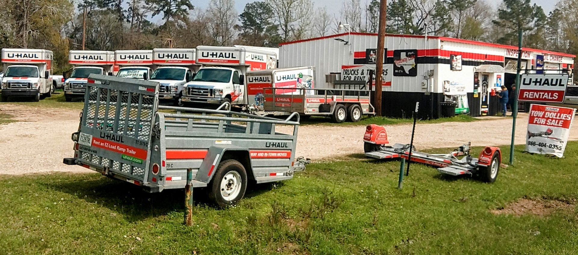 A trailer is parked in front of a u-haul truck