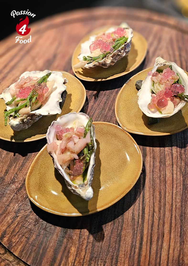 Ceviche van oesterzwam, gegarneerd met gehakte zeevruchten en kruiden, geserveerd op gouden borden.